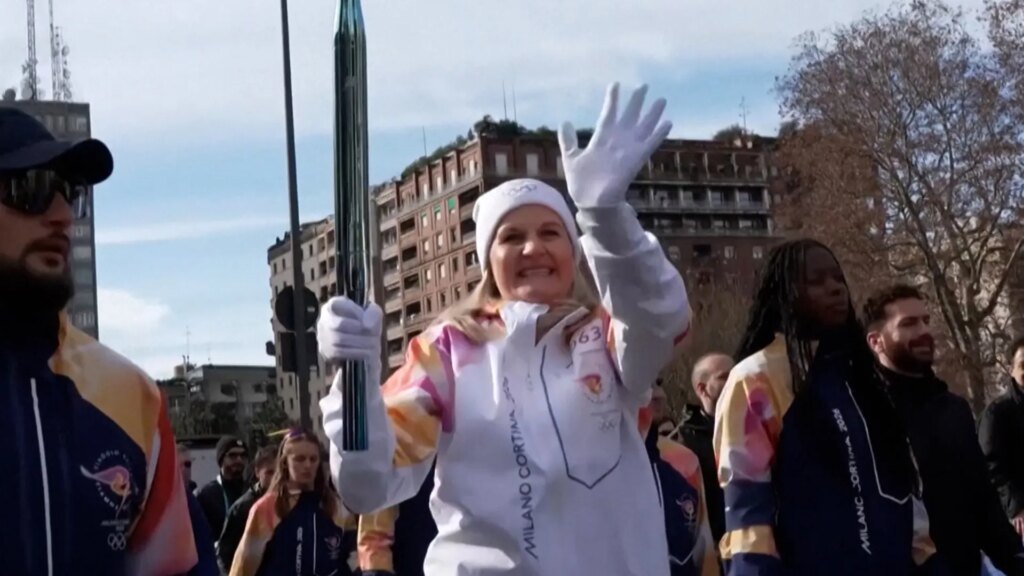 Olympic torch makes its way through central Milan just hours before the games begin.